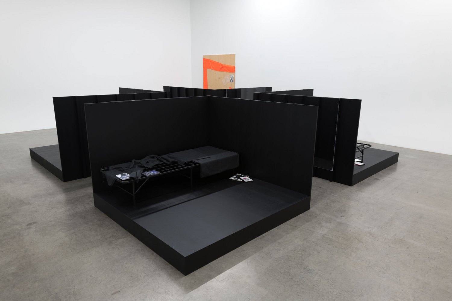 Tom Burr CONFIGURATION (NEXT) GENERATION, 2022 Stained plywood, plexiglass, metal bed frames, blankets, pillow, DVDs, magazines, books, clamps, straps 142 x 552 x 552 cm