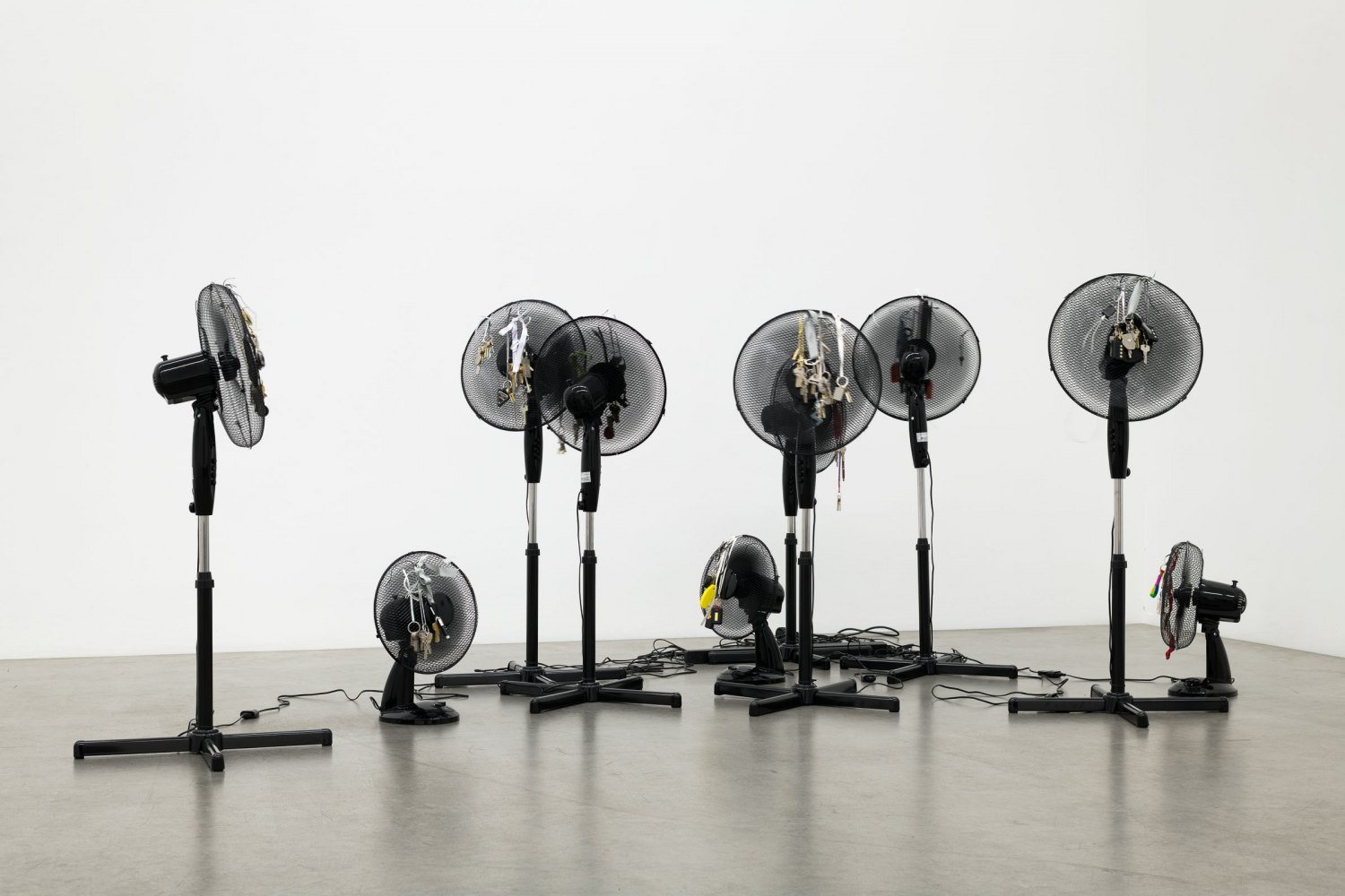 Iris Touliatou emotional infinity (the sound of them coming back amplified and looped), 2016/2024 10 oscillating pedestal fans, duplicated house keys, pre owned keychains, ribbons Dimensions variable