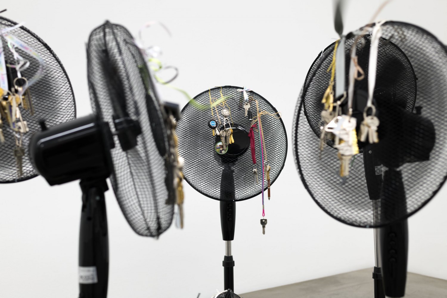 Iris Touliatou emotional infinity (the sound of them coming back amplified and looped), 2016/2024 10 oscillating pedestal fans, duplicated house keys, pre owned keychains, ribbons Dimensions variable