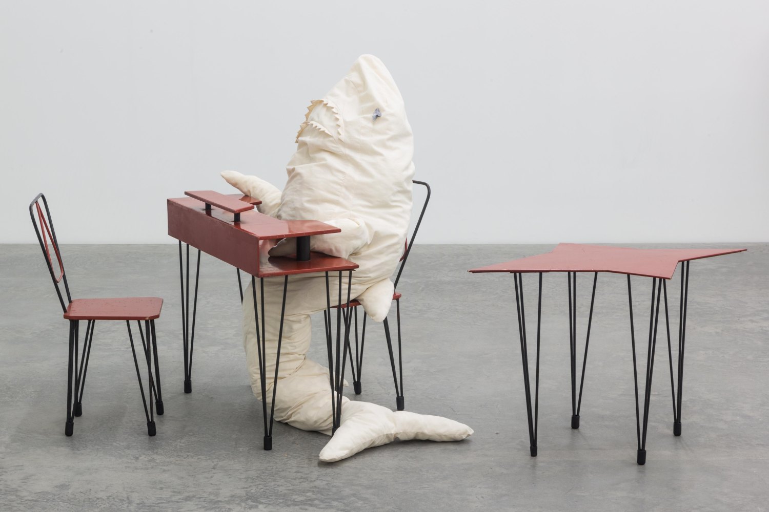 Cosima von Bonin HAI AM TISCH 1, 2014  Iron, blockboard, lacquer, rubber, cotton, terry, foam material, polyfill, bulb with fitting, cable, galvanized steel 180 x 50 x 30 cm (shark); 85 x 74 x 34 cm (table); 99 x 59,5 x 64 cm (table); 31 x 76 x 40 cm (chairs)