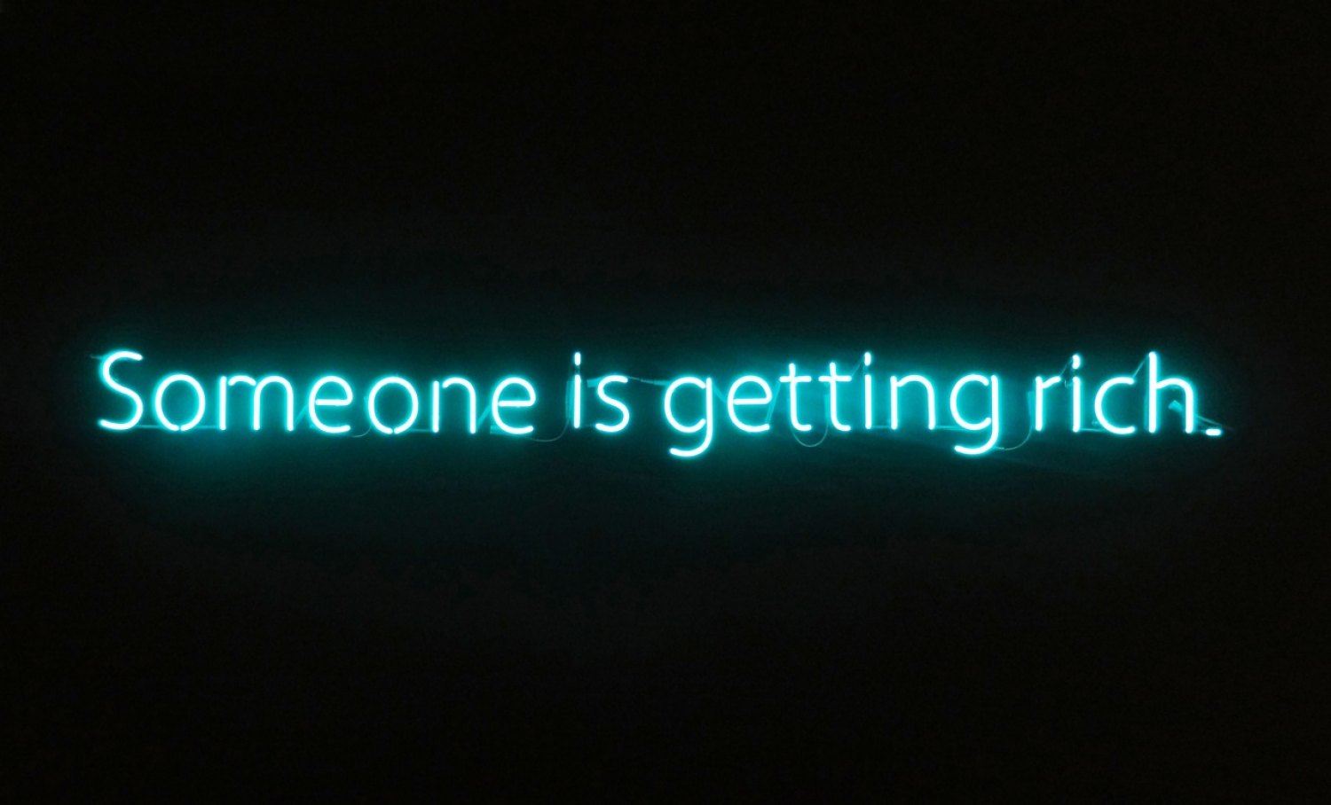 Claire Fontaine  Untitled (Someone is getting rich), 2012 Tecnolux No.9 Super Turquoise, 10mm glass, mounted to black painted wall, window or ceiling, 15 × 223 × 4 cm